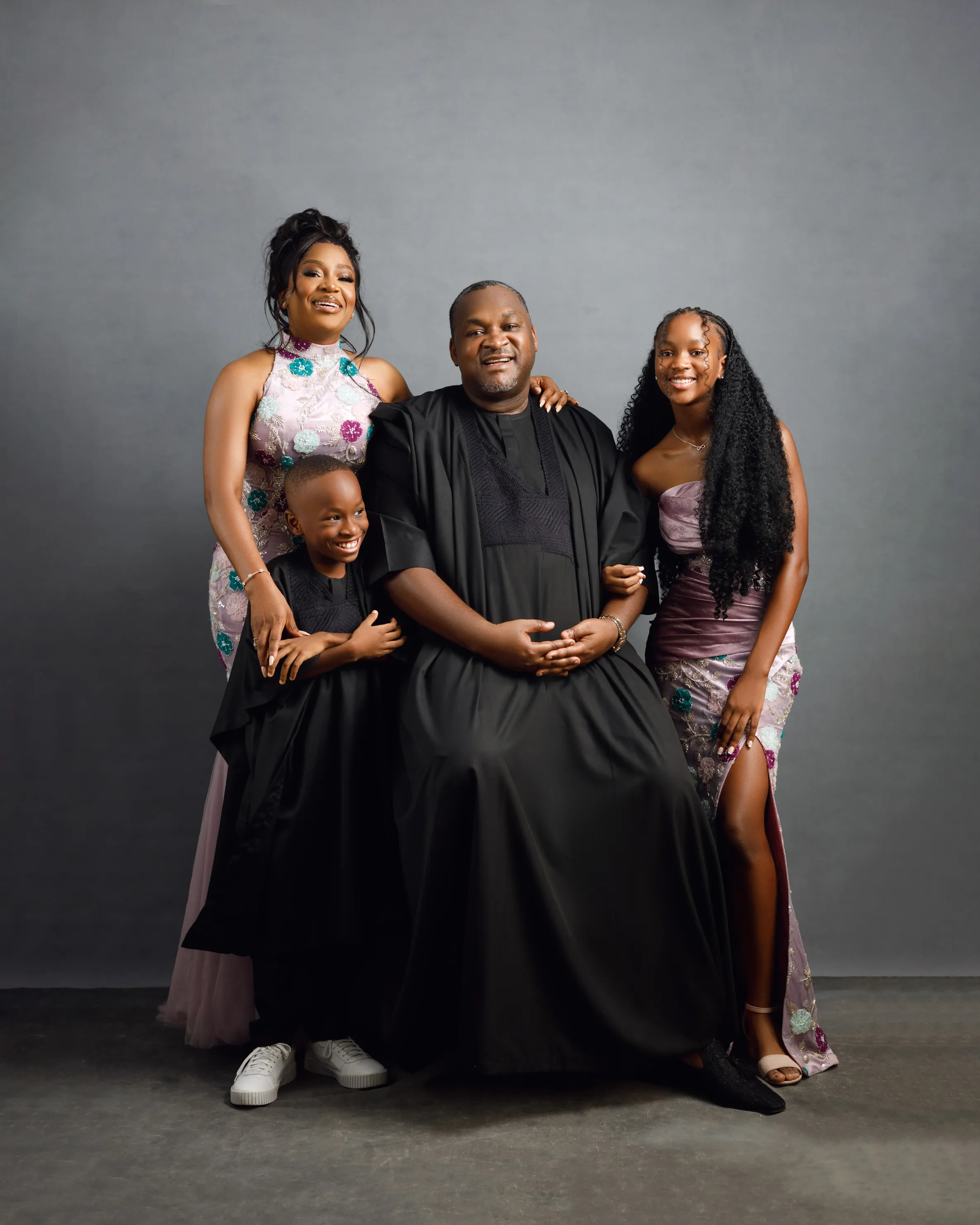 Joyful family of four posing together in a studio, Mrs. Shola family, Lagos.