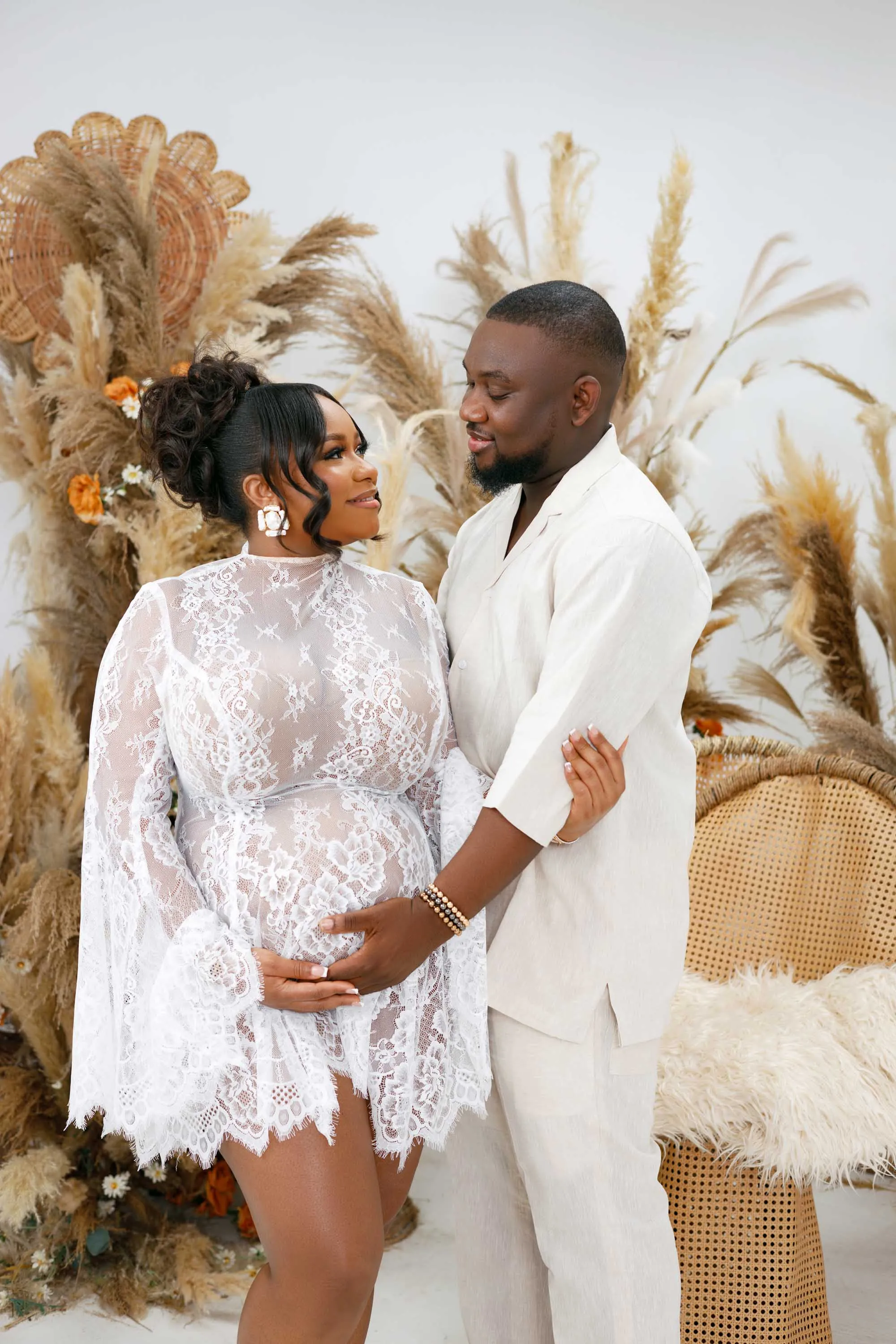Elegant maternity portrait of a woman in a flowing white dress, Lagos studio.